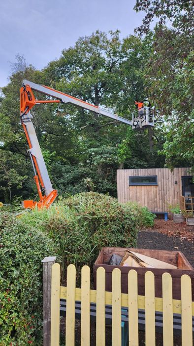 Working from a cherry picker over a garden fence